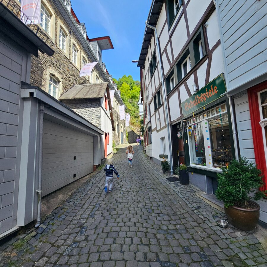 Cobbled street with shops and half-timbered houses in Monschau