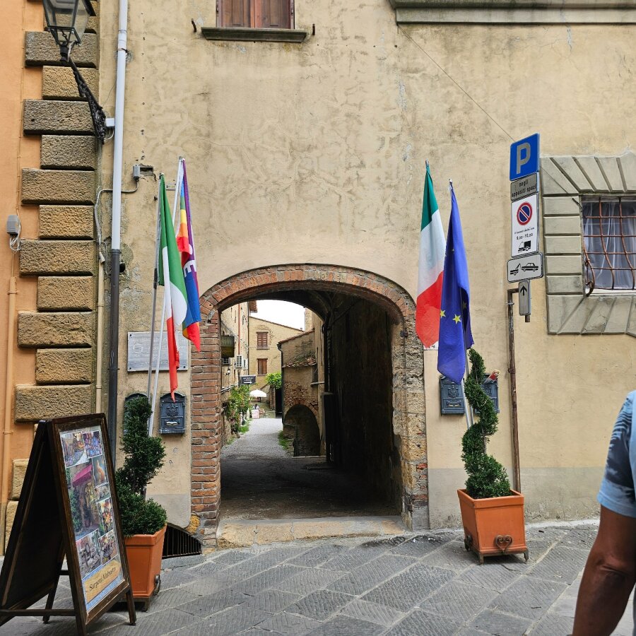 Gateway with Italian and European flags in Volterra
