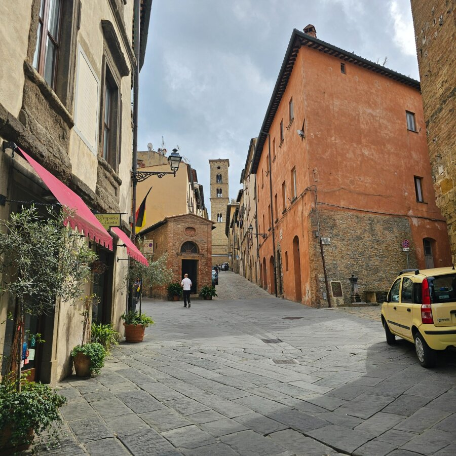 Street in Volterra with a medieval tower in the distance