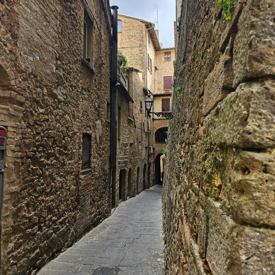 Narrow alley between stone walls in Volterra