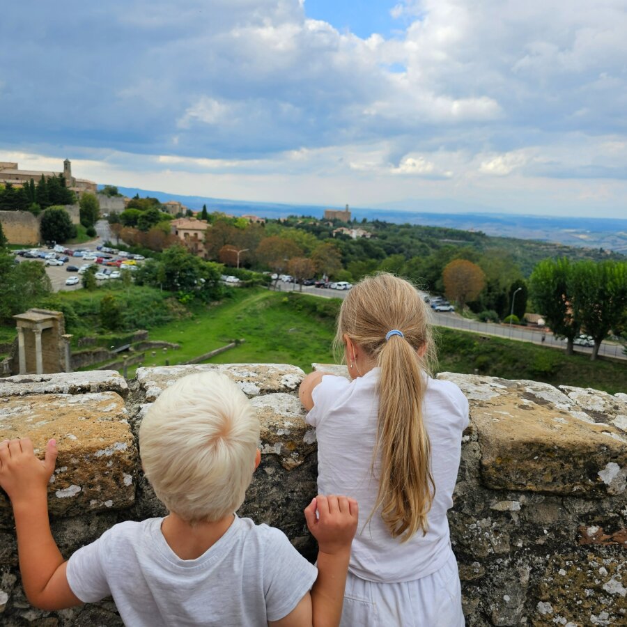 Two children looking over the wall at the Roman theatre