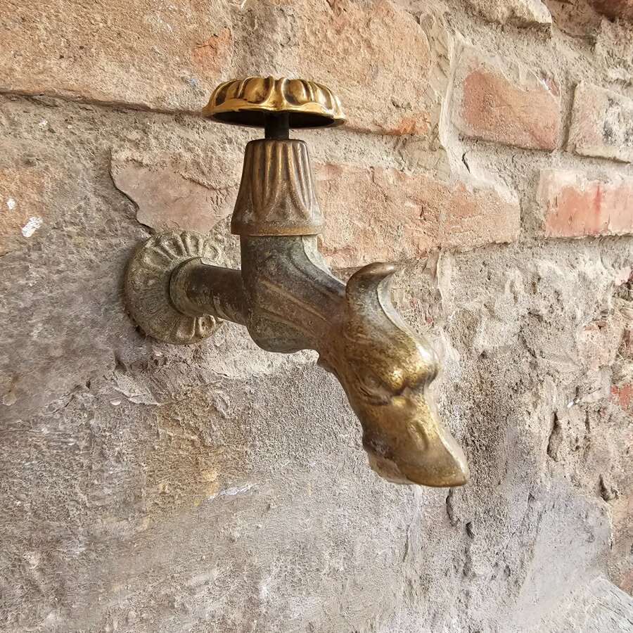 Brass tap on an old brick wall