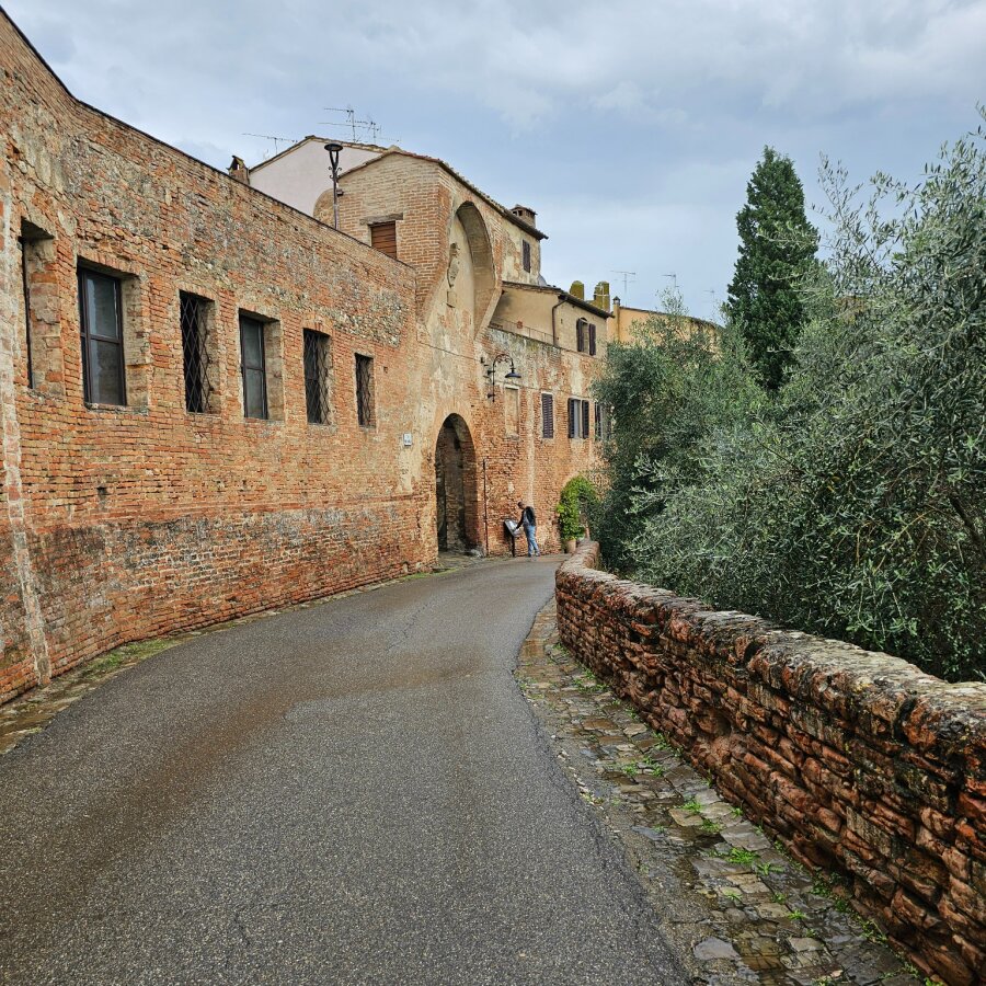 Road along the long brick walls of Certaldo Alto