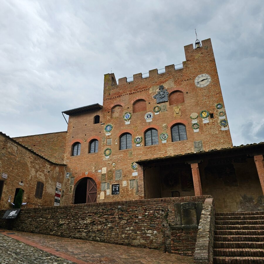 Brick palace with coats of arms on the facade in Certaldo Alto