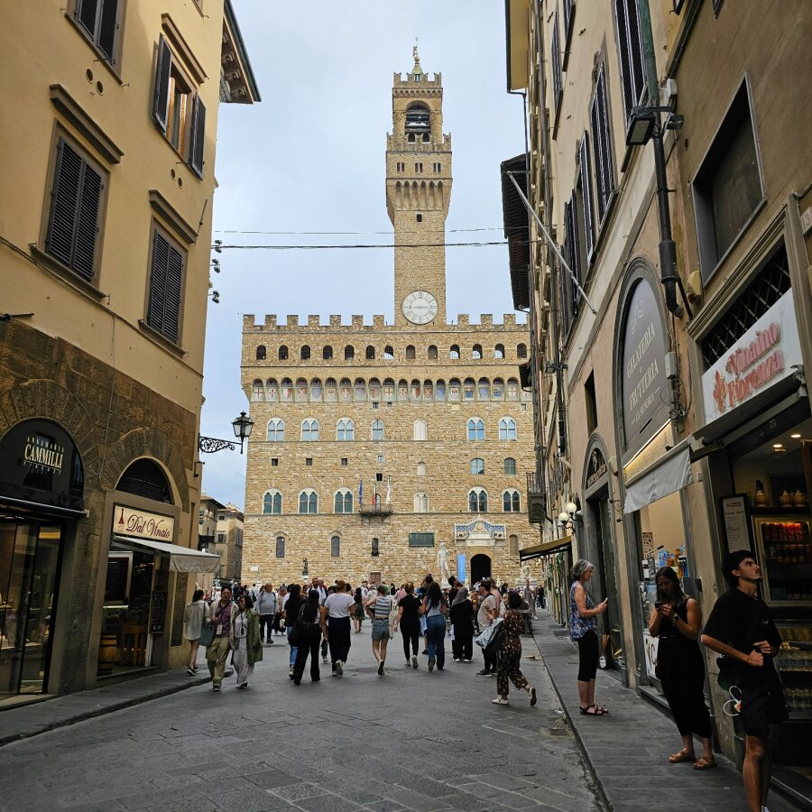 Busy street in Florence with the tower of Palazzo Vecchio