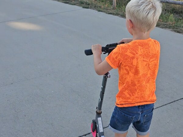 Child on a scooter along the path at Landal Park Eksel