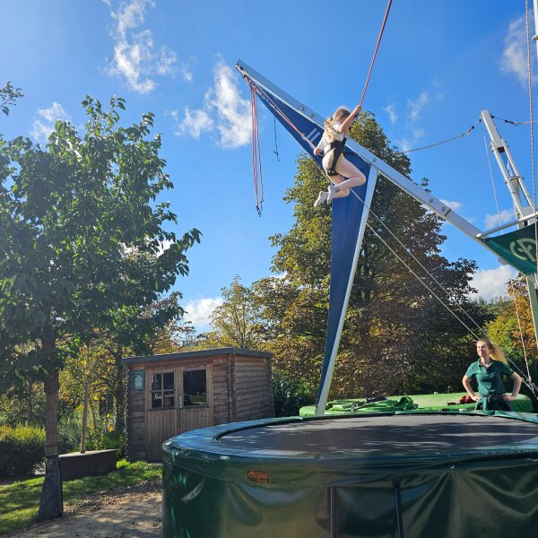 Child high in the air on the bungee trampoline on the park