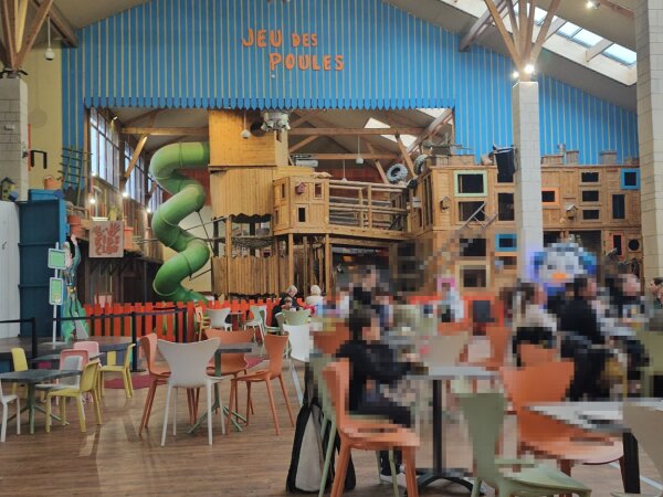 Indoor play hall with tables and a play structure at Center Parcs Les Trois Forêts