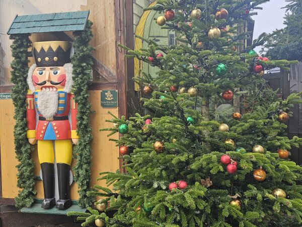 Large nutcracker beside a decorated Christmas tree in Trier