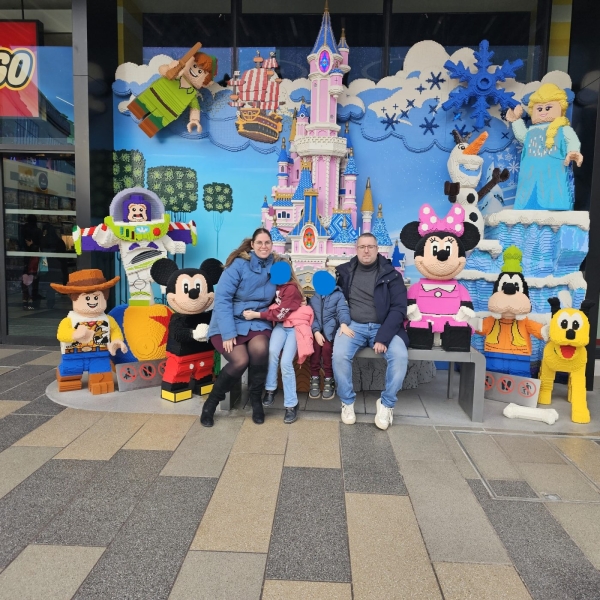 Family photo at LEGO Disney character display at Disneyland Paris entrance