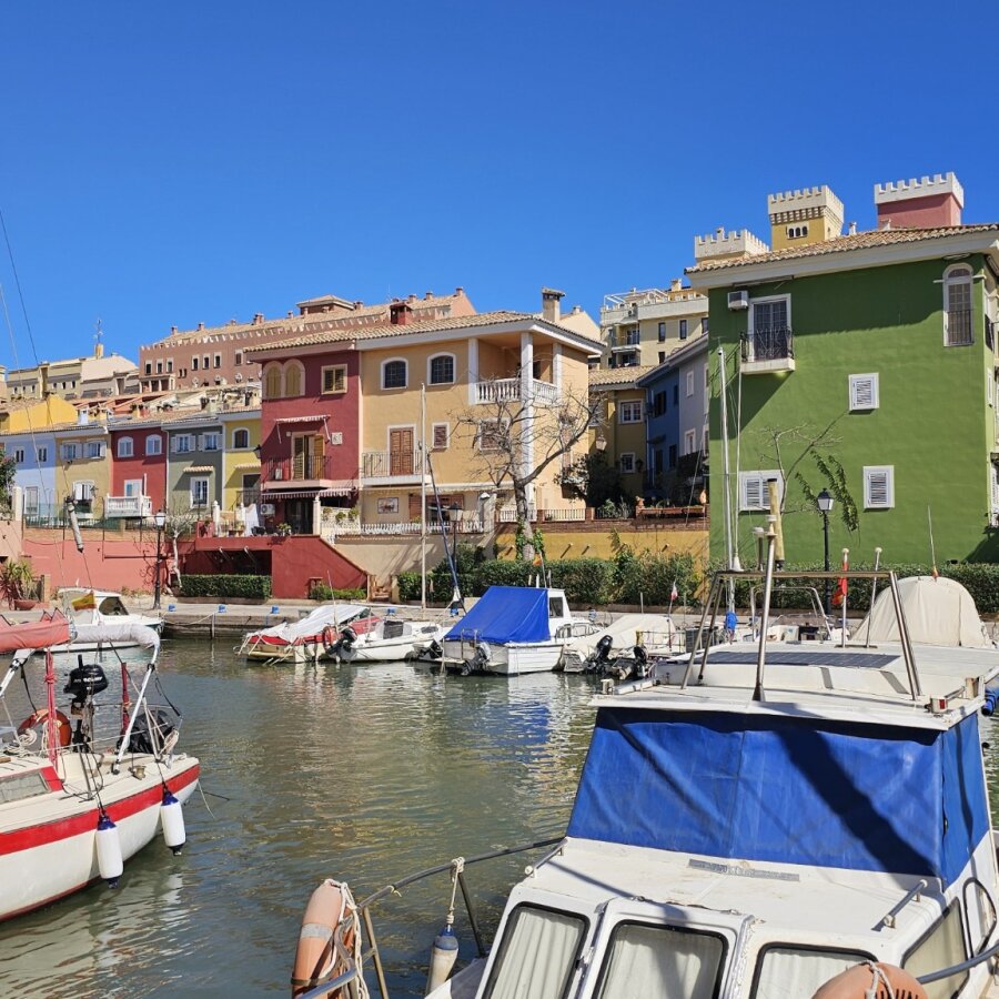 Colourful houses on the water with boats in Port Saplaya