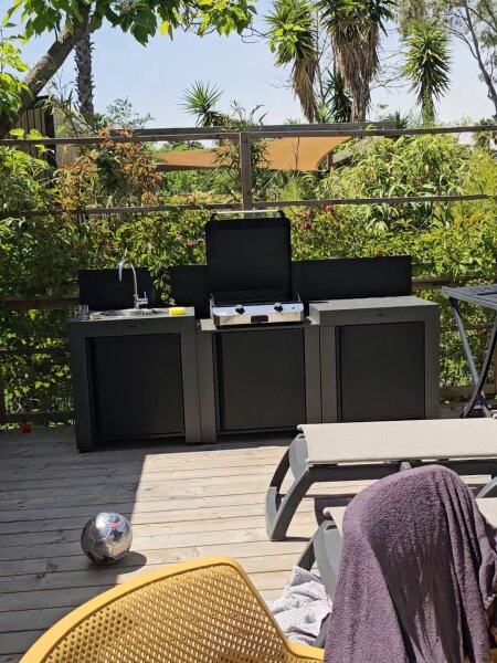 Buitenkeuken met gasplancha en spoelbak op het terras van de lodge