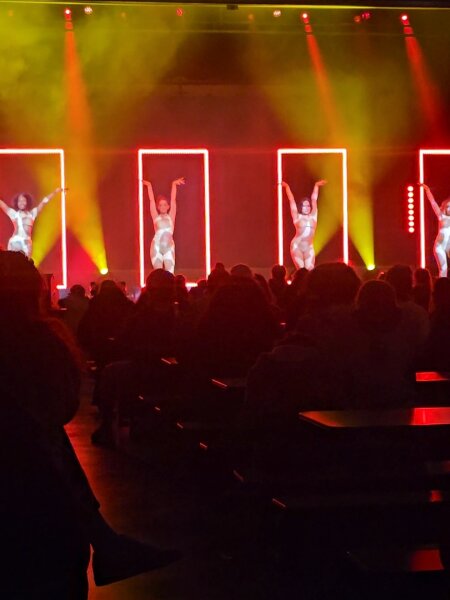 Dansers in rood podiumlicht in de Sirene Arena
