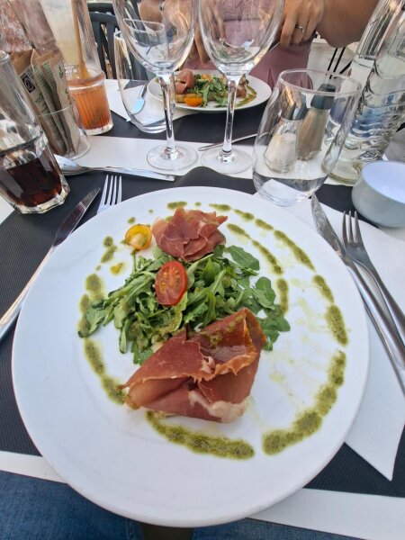 Voorgerecht met rauwe ham en rucola bij de dinner show