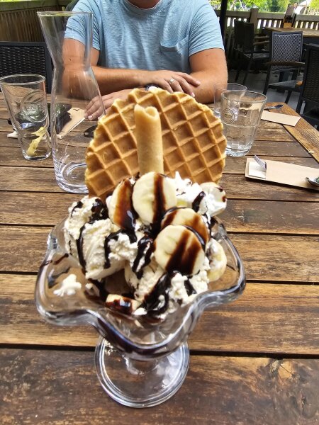 Large ice cream sundae with a waffle and banana on the terrace of the park brasserie