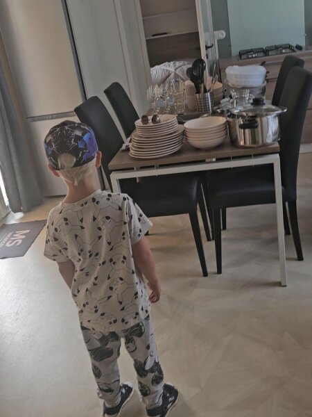 The kitchen and dining area of the Santa Fe Premium lodge, with crockery, glasses, pans and utensils stacked on the table.