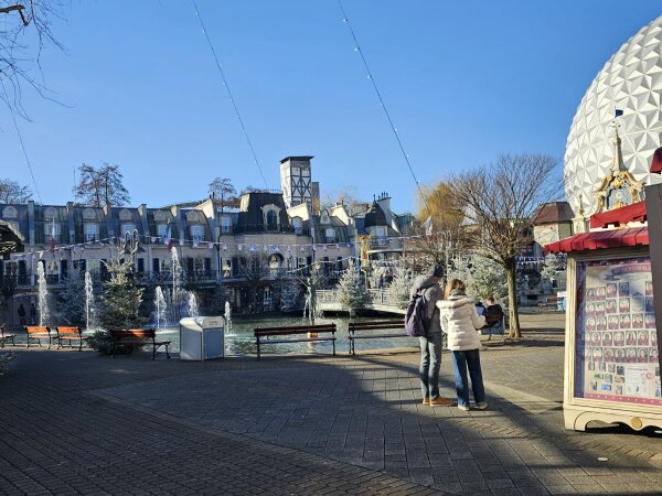 The French quarter at Europa-Park on a clear winter day, with fountains, frosted trees and the silver dome behind them.