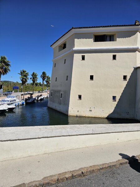 Verhuurboten aangemeerd in het kanaal van Port Grimaud naast een groot wit gebouw