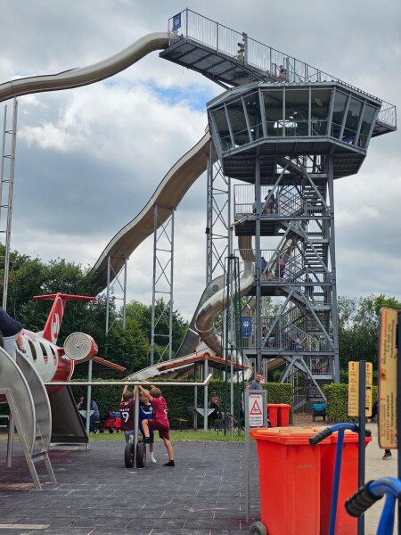 Lookout tower with two long slides, with an aeroplane in the playground in front