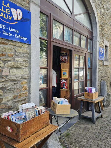 La Bulle aux BD comic shop in Redu with crates of books on small tables by the door